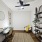 Bonus room with wood plank flooring, ceiling fan, desk with mirror, chair, and bookshelf