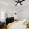 Bedroom with king sized bed, wood plank flooring, ceiling fan, and two doors leading to closet