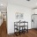 view of wood plank flooring, long corridor hallway, dining table, stainless steel refrigerator and wood cabinetry